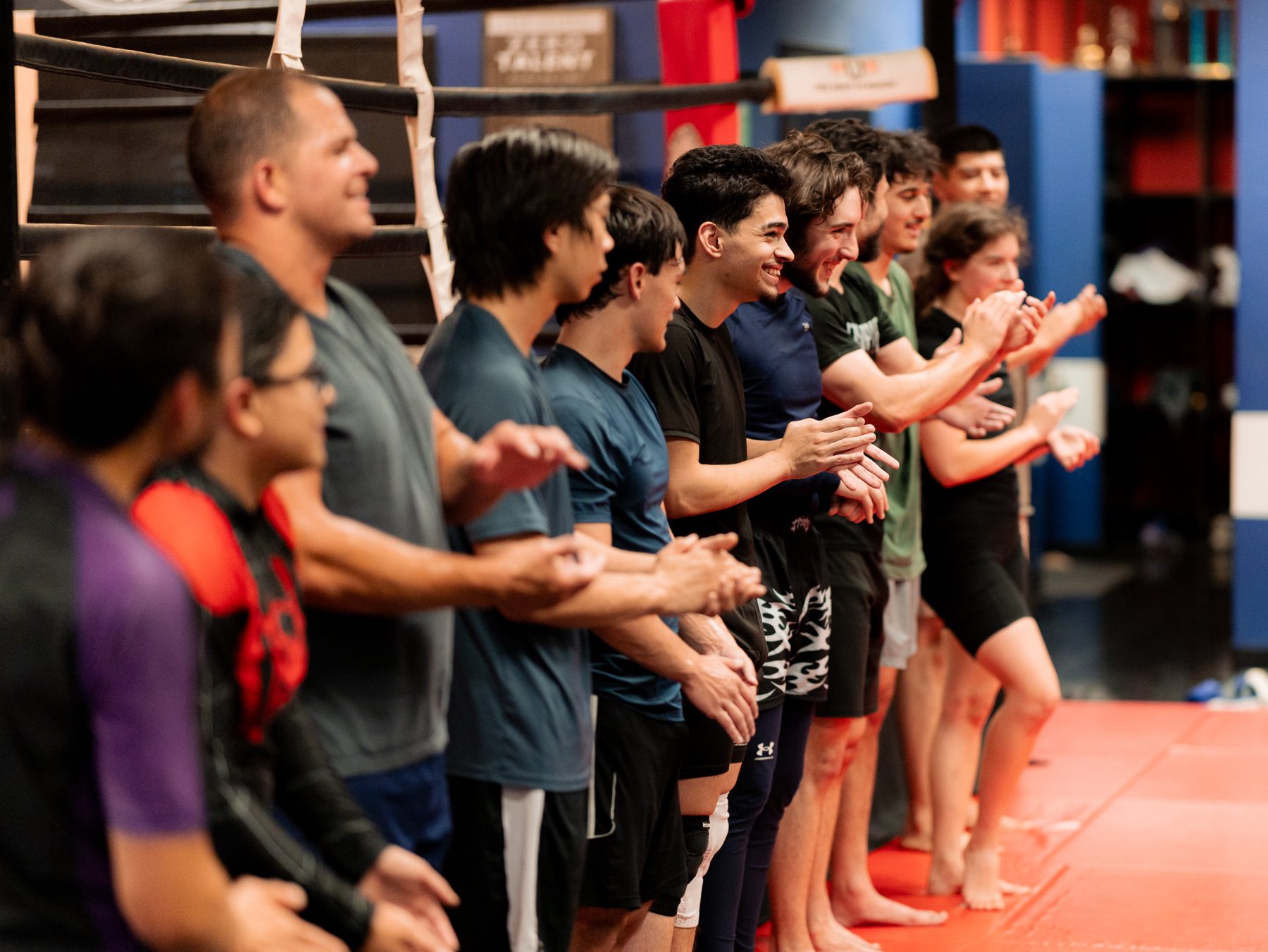 Loyal Legion students lined up on the mat, clapping and celebrating together after class.